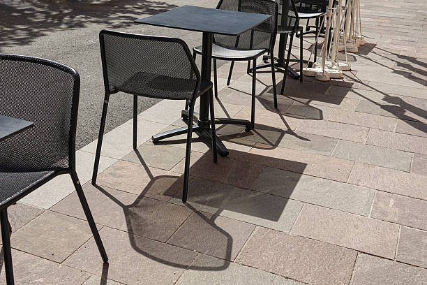 A top view showing row of white chairs are set up in a row on a sidewalk. There are three sets of chairs, with one set of chairs on the left, another set of chairs in the middle
