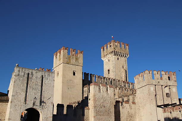Sirmione, Italy - 5 May 2018: Sirmione in Italy shows Scaliger Castle, medieval walls, Lake Garda views, Roman ruins, historic old town, narrow streets, thermal spas, stone houses, cultural heritage, tourist destination, and scenic landscape.