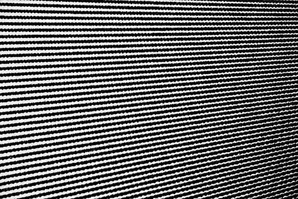 Extreme close-up of horizontal black lines printed on white paper, showing wavy distortions and ink bleed along the edges.