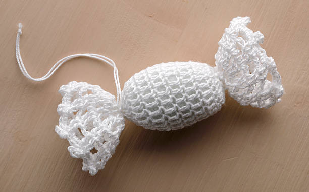 White crocheted candy ornament on beige background