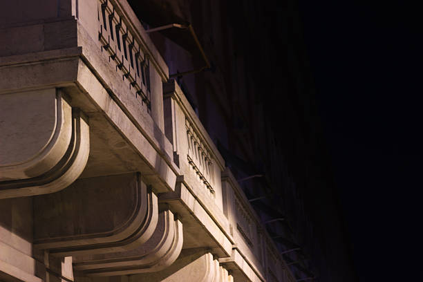 Lisbon, Portugal - April 5, 2019: Close-up of a row of typical Lisbon balconies lit by artificial lights, while the building fades into the night shadows