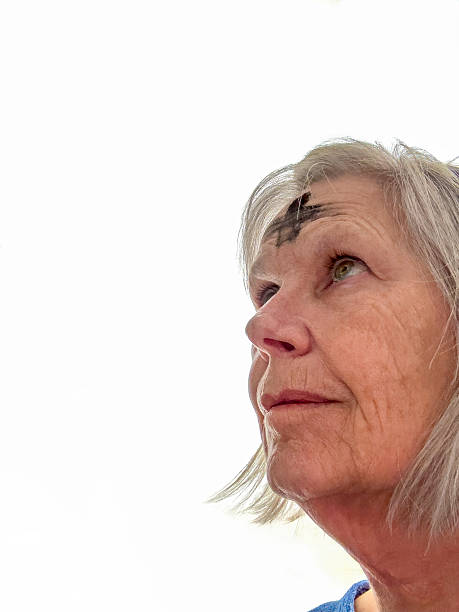 Senior woman with ashes on her forehead in observance of Ash Wednesday, the beginning of Lent