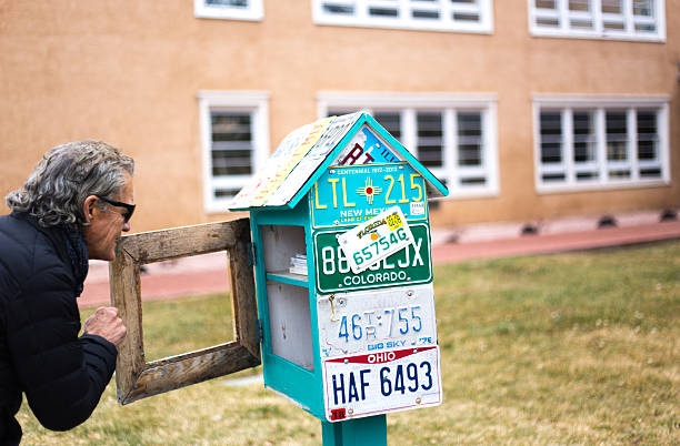 Santa Fe, NM: A man looks into a Little Free Library bookcase in downtown Santa Fe.