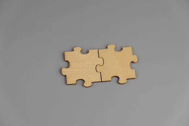 istock wooden puzzle on plain color paper with text space concept. 2253986902