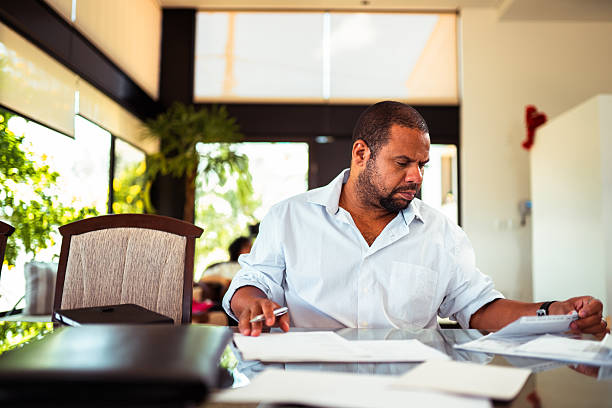 istock Mature man diligently working on paperwork at a bright, contemporary workspace. 2253987269