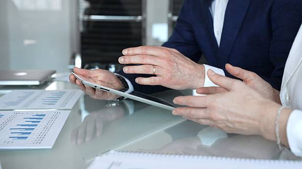 istock Business partners collaborating on financial data, discussing market trends, analyzing charts, and reviewing reports on a tablet during an office meeting. Concept of teamwork, finance, and 2253989362