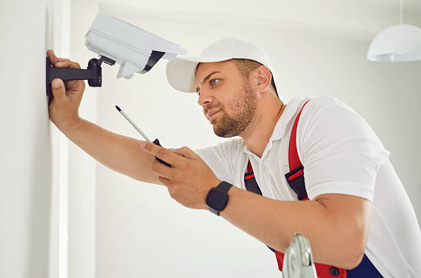 istock Male security camera installer installing or repairing surveillance camera on wall indoors. 2253989940