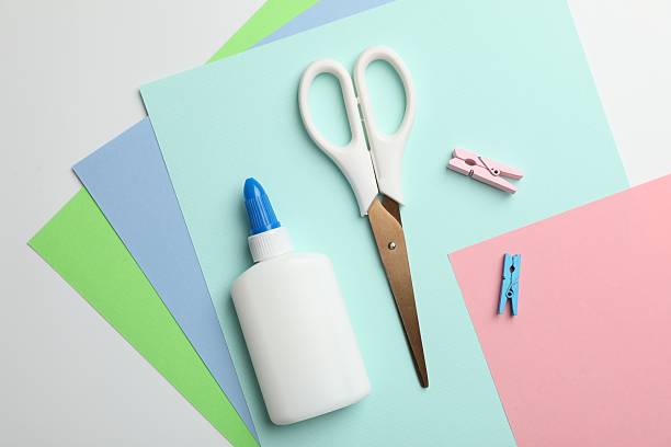 istock Glue, scissors, clips and color paper on white background, flat lay 2253992271