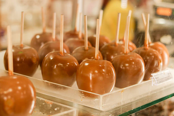 A collection of handcrafted caramel apples coated with crunchy nuts, photographed under warm lighting to highlight texture, shine, and artisanal detail. These images capture the richness and sweetness of traditional caramel apples, perfect for seasonal promotions, dessert concepts, and gourmet food content.