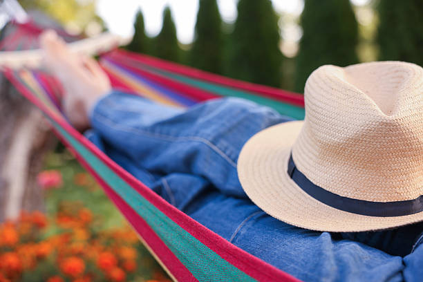 Senior woman with straw hat resting in hammock outdoors, closeup