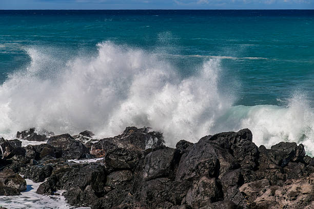 Landscape of the coastline of Lanzarote with the atlantic ocean and a breaking and splashing wave.