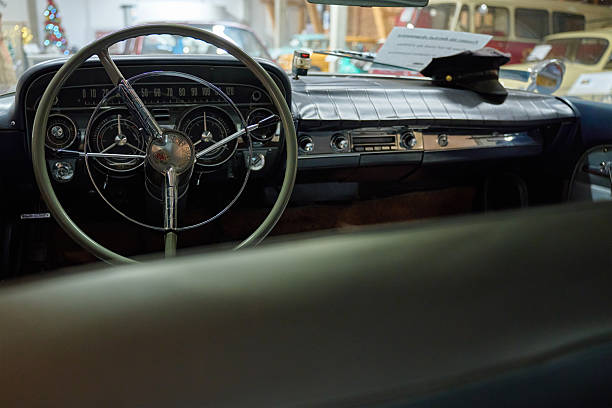 Retro Buick car interior with a steering wheel and classic dashboard with classic gauges and chrome details. Inside view of vintage vehicle. Wroclaw, Poland - December 04, 2022
