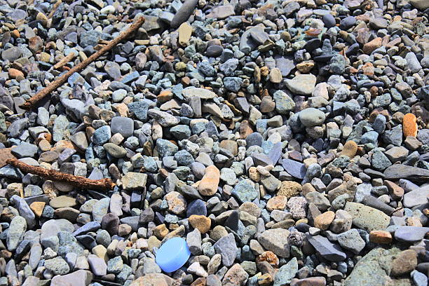 Steady balanced pyramid of sea-polished bottle shards on the seashore.