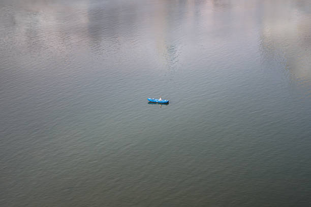 A small colorful wooden boat observed between low walls. Bucolic scene viewed from Urca Beach, Rio de Janeiro.