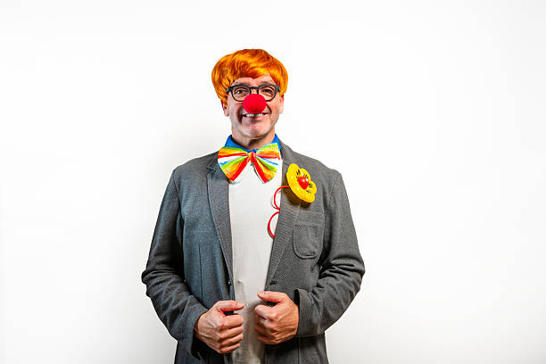 istock Clown wearing red nose and rainbow bowtie smiling at camera 2254009547