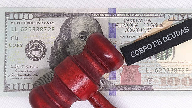 istock Judge gavel on $100 bill with debt collection stamp 2254011252