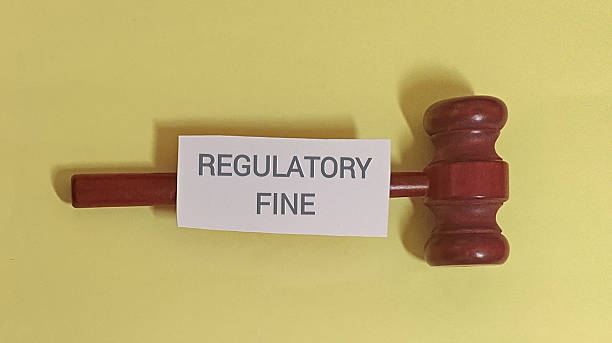 istock Regulatory fine concept with gavel on yellow background 2254011397