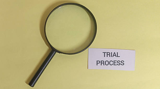 istock Magnifying glass on trial process note for investigation and research 2254011459