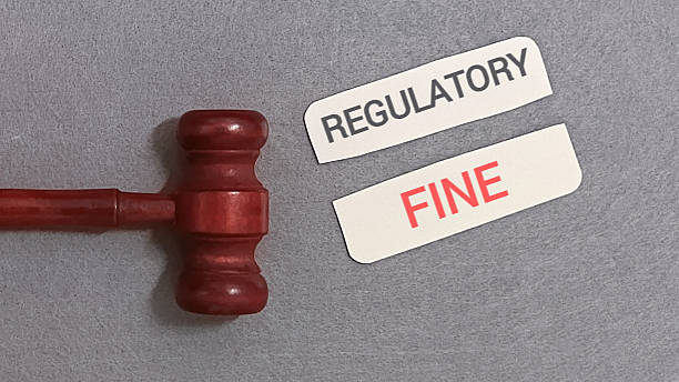 istock Judge gavel with regulatory fine labels on gray background 2254011539