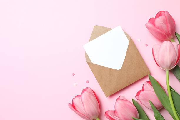 istock Beautiful fresh tulips with paper envelope on color background 2254012845