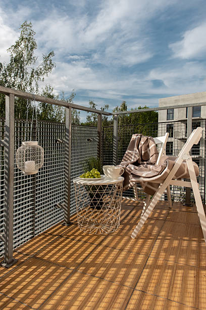 istock Modern Balcony Lounge With Chairs, Table, and Relaxing Niches in Urban Setting 2254017521