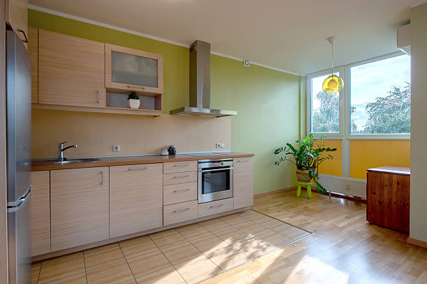 A bright and modern kitchen that features beautiful white cabinetry and a warm wooden countertop for comfort
