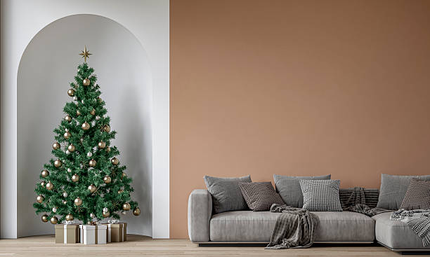 istock Modern minimalist interior decorated for Christmas, with sofa in front of subtle caramel plaster wall, a Christmas tree with presents in a wall niche, near a window 2254018264