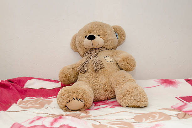 istock Lonely teddy bear sits on the bed 2254018337