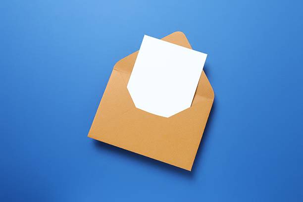 istock White paper card with craft envelope on blue background 2254018657