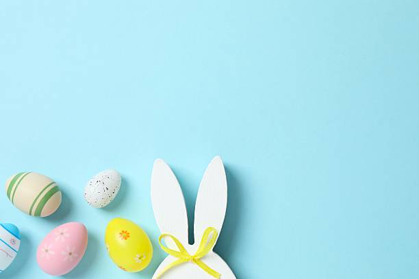 istock Happy Easter. Colorful eggs with bunny ears on color background, space for text or advertising 2254018928