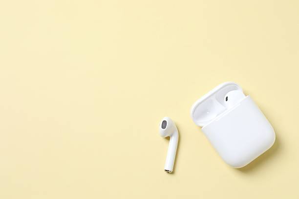 istock Wireless ear phones with a white box on color background 2254018953