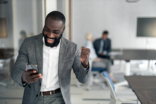 istock Professional Man Celebrates Success At The Office While Looking At His Phone With Joy 2254019656