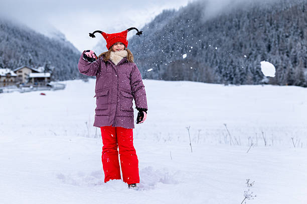 A pretty little girl dressed in red stands out against the white winter landscape of the meadows and woods around Cogne, in the Aosta Valley. She is very happy about the snowfall on Christmas Day. She throws a snowball at me, but luckily misses. What a disaster it would have been if she had aimed better, just a little bit more on the left...