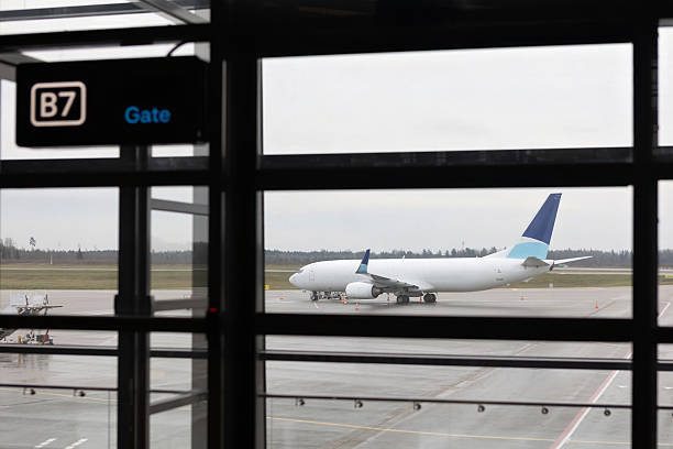 istock Airplane on runway seen through airport gate window 2254032606