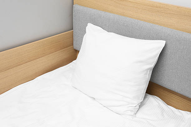 istock White bed pillow closeup. Clean hotel bedding detail. Soft fabric texture background. 2254037580