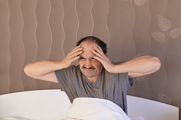 istock Frustrated middle-aged man waking up with severe headache 2254037753