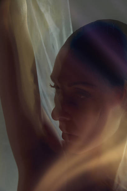 istock Close-up dancer face and arm in warm atmospheric motion with soft translucent fabric. 2254038688