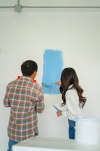 istock The painter is painting the house's wall. 2254040520