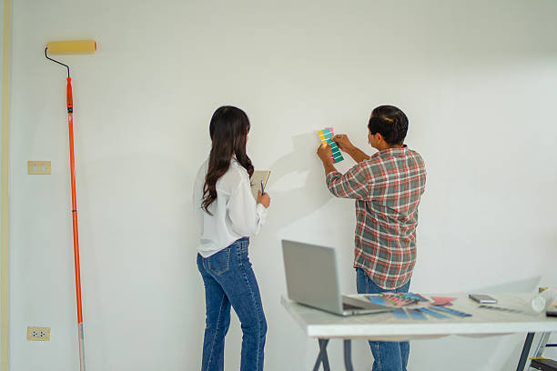 istock The painter is painting the house's wall. 2254040547