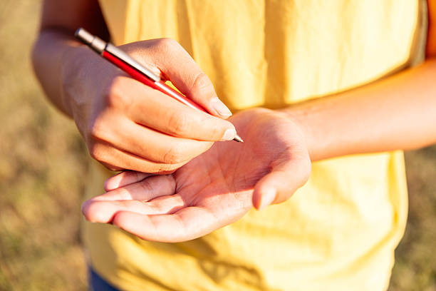 istock Woman writing notes on hand with pen in sunny outdoor setting 2254041722