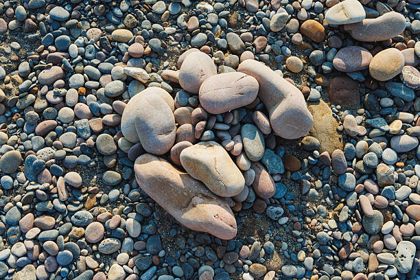 Smooth pebbles of various shapes and sizes cover the beach, glistening under the sun, creating a natural mosaic that invites visitors to pause and connect with nature s beauty.