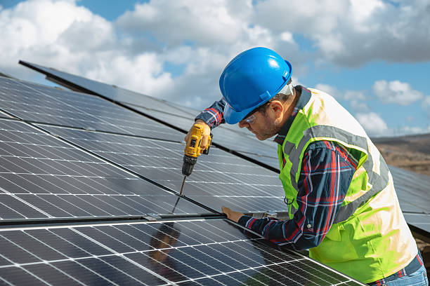 istock A solar panel installer, equipped with a drill, is in the process of installing solar panels on a solar energy power station on a sunny day 2254044731