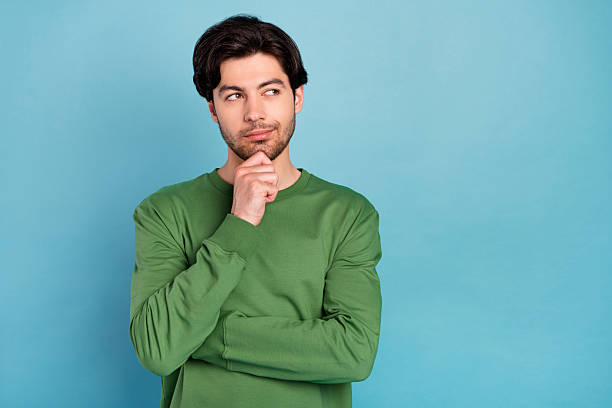 istock Photo of young thoughtful minded smiling guy thinking look copyspace dreaming isolated on blue color background 2254046784
