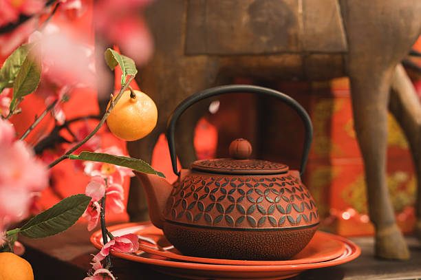 The Chinese hot tea set with orange fruit and a red envelope called AngPao and ornament accessories for Chinese New Year