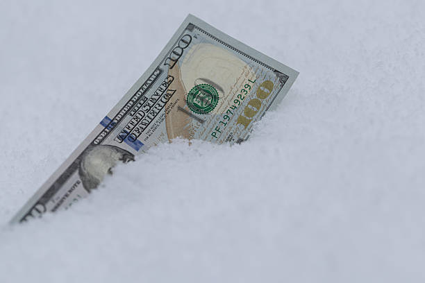 istock One Hundred Dollar Bill Buried in Snow 2254057482