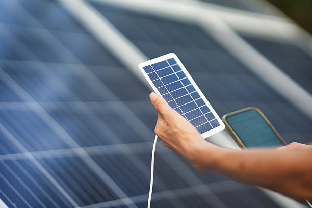 istock Hand Holding Portable Solar Panel Near Solar Panels 2254058266