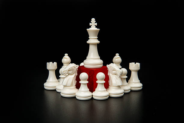 istock Central white king elevated on red pedestal surrounded by chess pieces representing authority, strategic control, leadership command, and organizational hierarchy in business environments. 2254058330