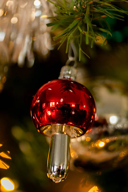 Red ornament hanging from a string. The ornament is a Christmas ball. The image has a festive mood