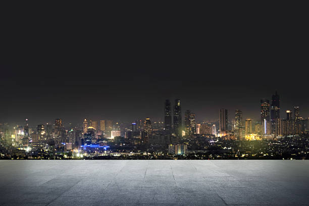 istock Cityscape background with blurry building lights, pavement, and empty space on top. Product presentation, mockup, copy space, and template 2254059359