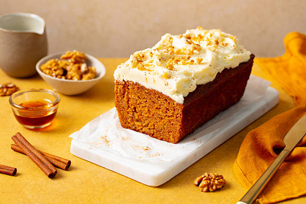 istock Carrot cake loaf on a white marble serving board. Yellow background. Close up. 2254067296